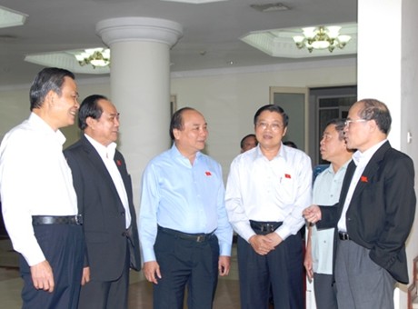 Chủ tịch Quốc hội Nguyễn Sinh Hùng cùng Phó Thủ tướng Nguyễn Xuân Phúc trao đổi với các đại biểu Quốc hội. Ảnh VGP/Lê Sơn