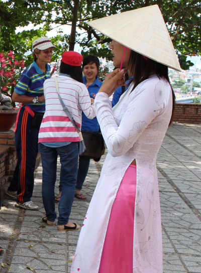 Hướng dẫn viên du lịch duyên dáng với áo dài, nón lá.