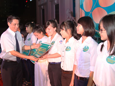 Đồng chí Lê Đức Vinh trao phần thưởng cho các em học sinh. Ảnh: THÀNH AN