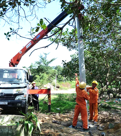 Công nhân Điện lực Cam Lâm dựng cột kéo điện đến các hộ dân.