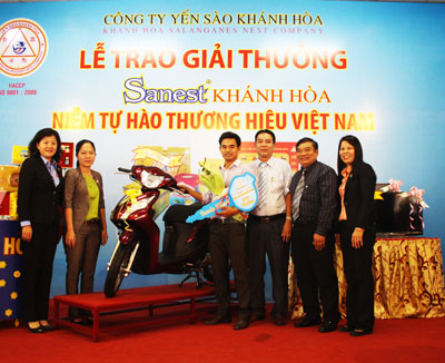 Khách hàng Nguyễn Ngô Bá Toàn (thứ 4 từ phải sang)  nhận giải thưởng xe máy Honda Vision.