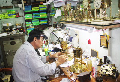 Anh Nguyễn Hữu Tuấn đang sửa đồng hồ.