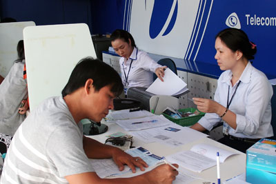*Nhân viên giao dịch Trung tâm Viễn thông Cam Ranh hướng dẫn khách hàng đăng ký thông tin thuê bao di động trả trước của Vinaphone.