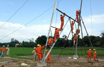 Công nhân Công ty Cổ phần Điện lực Khánh Hòa kéo đường dây điện mới tại xã Cam Tân, huyện Cam Lâm trong năm 2013.