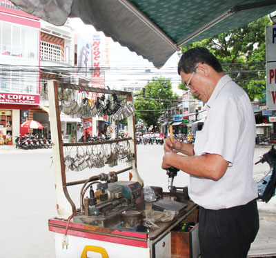 Ông Phan Quốc Việt sửa khóa trên đường Thống Nhất.