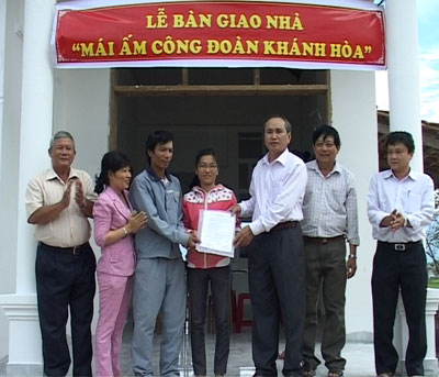  Ông Nguyễn Hòa - Chủ tịch Liên đoàn Lao động tỉnh (thứ 3 bìa phải) trao quyết định bàn giao nhà cho gia đình chị Diễm.