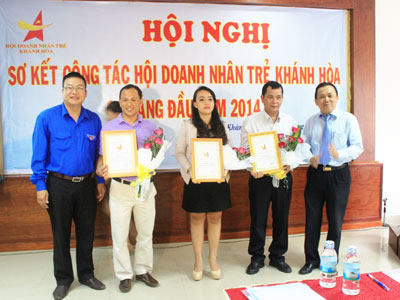 Ông Lê Hữu Hoàng - Tổng Giám đốc Công ty TNHH Nhà nước một thành viên Yến sào Khánh Hòa, Chủ tịch Hội Doanh nhân trẻ Khánh Hòa (bìa phải) tặng hoa chúc mừng 3 hội viên mới. 
