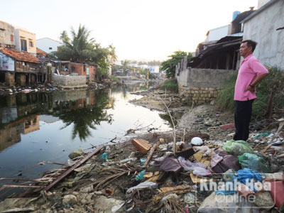 Đứng cạnh dòng sông ngập rác, ông Phan Thế Bản không khỏi xót xa.