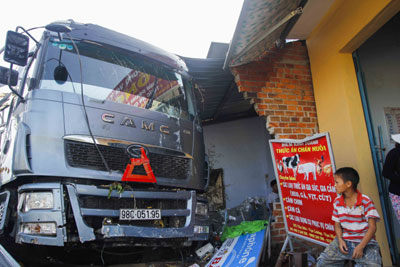 Đầu xe đâm thẳng vào nhà dân và làm xập 1 phần tường nhà.