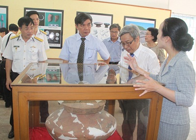 Các đại biểu nghe hướng dẫn viên Bảo tàng giới thiệu về những nét nổi bật của  triển lãm.