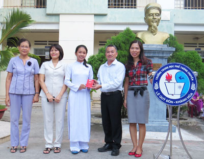 Nhóm cựu học sinh trao học bổng cho em Xuân Hiền. 