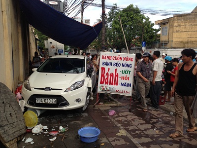 Chiếc ô tô con 79A-02849 lao vào hàng quán trên vỉa hè nhưng rất may không có ai bị thương.