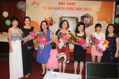 Đại diện Lyz’s Spa (bìa trái) trao giải thưởng dành cho những con số may mắn cho khách. 