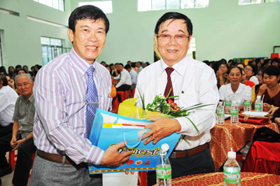 Ông Trần Nguyên Lập - Trưởng phòng Giáo dục và Đào tạo TP. Nha Trang (bên trái) tặng hoa và quà cho các thầy cô giáo.