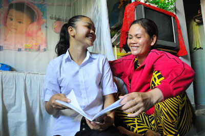 Em Võ Thị Kim Ngân, học sinh lớp 6 Trường THCS Cao Thắng, Nha Trang  khoe với mẹ kết quả học tập ở trường.