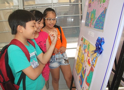 Các em thiếu nhi xem tranh tại triển lãm.