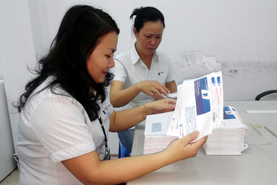 Nhân viên thu cước Trung tâm Kinh doanh Viễn thông Khánh Hòa chuẩn bị giấy báo, hóa đơn đến thu cước tại nhà thuê bao.