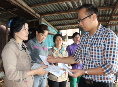 Ông Nguyễn Khắc Hà trao hỗ trợ cho các hộ dân có nhà bị sóng biển đánh sập. 