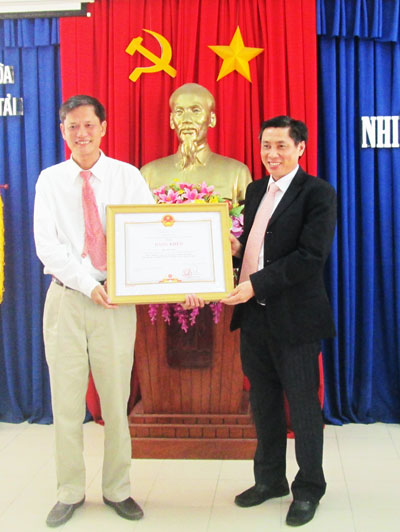 Đồng chí Lê Đức Vinh (bìa phải) trao bằng khen của Thủ tướng Chính phủ cho ông Phù Minh Sơn.