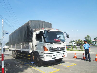 Thanh tra giao thông hướng dẫn xe vào trạm cân tải trọng.