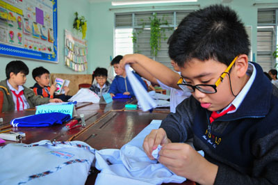 Các học sinh nam khá khó khăn với phần thi gấp áo quần.