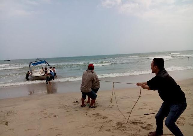 Lực lượng chức năng đưa chiếc ca nô lên bờ. 