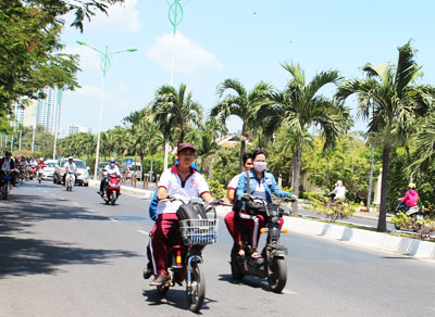 Nhiều học sinh khi tham gia giao thông không đội mũ bảo hiểm và đi hàng đôi. Ảnh: V.G