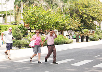 Nhân viên khách sạn Sunrise dẫn khách qua đường.