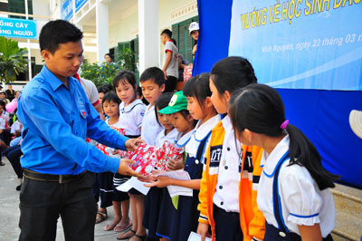 Ban tổ chức trao quà cho các học sinh nghèo vượt khó.