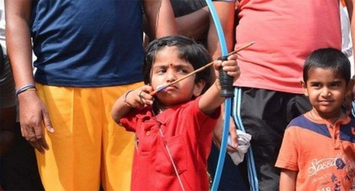 Dolly bình thản bắn cung trước sự theo dõi của các quan chức và người thân. Ảnh: Reuters