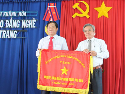 Ông Mai Thu - Phó Giám đốc Sở Nội vụ (bìa phải) trao cờ thi đua cho trường.