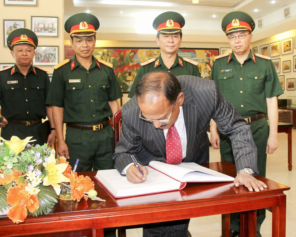 Ngài Ajit Doval ghi sổ lưu niệm nhà truyền thống Trường Đại học Thông tin liên lạc.