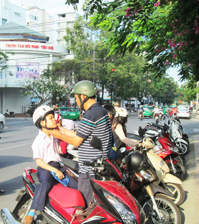Nhiều phu huynh chấp hành tốt việc đội mũ bảo hiểm cho con em