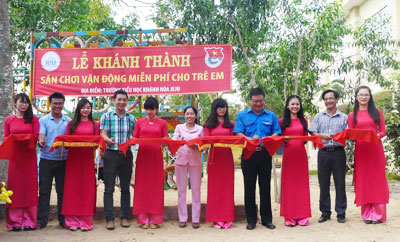 Các đại biểu cắt băng khánh thành sân chơi.