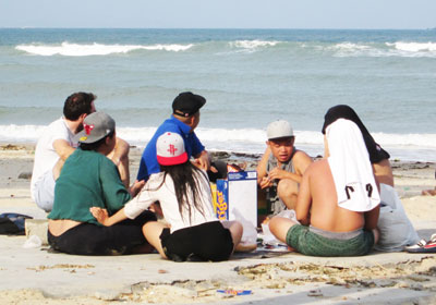 Nhóm thanh niên tụ tập ăn uống trên công viên bờ biển.