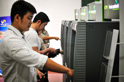 Khách hàng rút tiền tại máy ATM của ngân hàng Vietcombank. Ảnh: VĨNH THÀNH