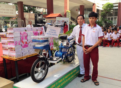 Đại diện nhà tài trợ tặng xe đạp điện cho em Nguyễn Thái Phong, học sinh hiếu học, vượt khó tiêu biểu. 