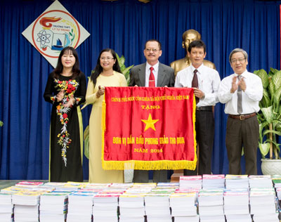 Đồng chí Lê Xuân Thân trao cờ thi đua của Chính phủ cho trường.