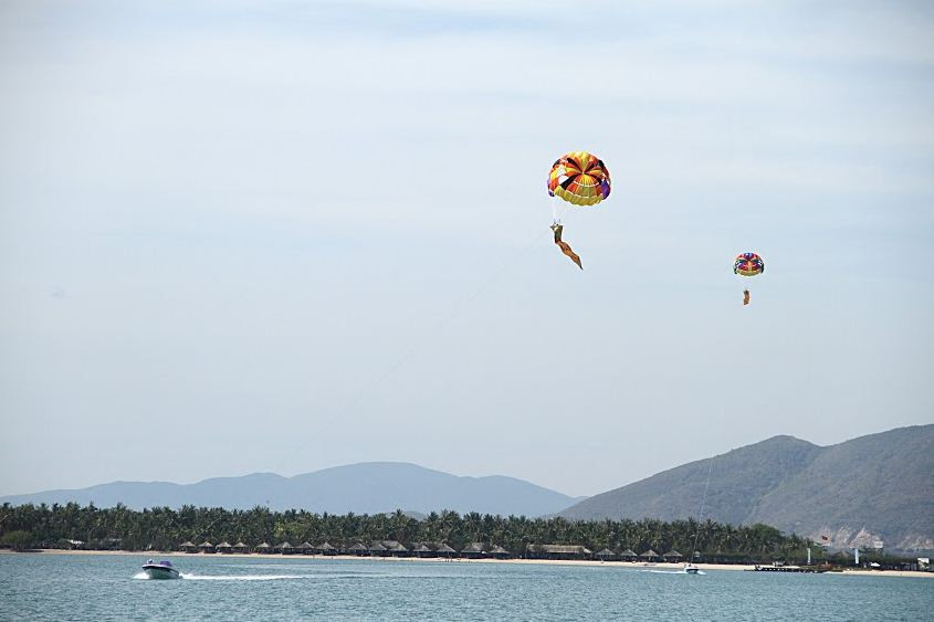 Ca nô kéo dù bay trên mặt đầm Nha Phu.