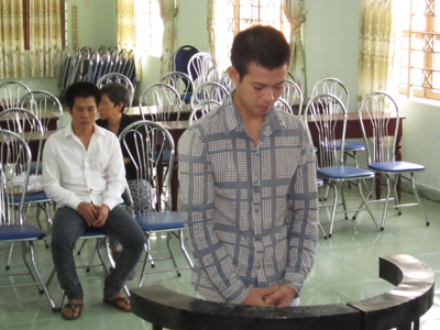 Bị cáo Tuấn (ngồi) và Bình trước vành móng ngựa.