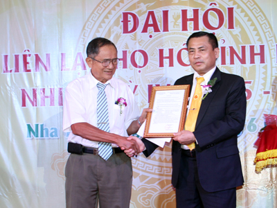 Đại diện Quỹ Khuyến học tỉnh Khánh Hòa (phải) trao quyết định kết nạp quỹ khuyến học họ Hồ làm thành viên.