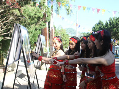 Các bạn trẻ huyện Khánh Sơn xem triển lãm ảnh về những thành tựu của địa phương.
