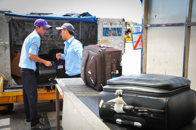 Các nhân viên bốc xếp trả hành lý cho khách.