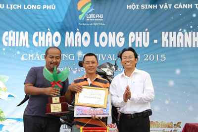 Ông Lê Dũng Lâm – Giám đốc công ty cổ phần du lịch Long Phú (bên phải) trao giải cho chủ nhân chú chim chào mào đạt giải nhất. 