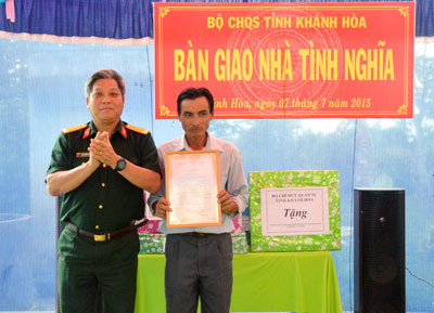 Đại tá Ngô Quang Trung - Chỉ huy trưởng Bộ Chỉ huy Quân sự tỉnh trao quyết định tặng nhà cho ông Đặng Hữu Lộc.