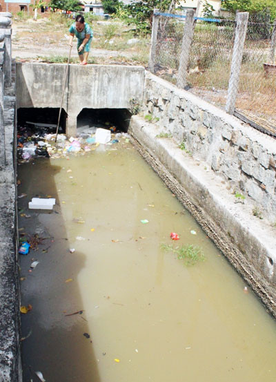 Khi lực lượng chức năng chưa kịp vớt rác tại rào chắn, thì người dân gần đó cũng tự làm việc này.