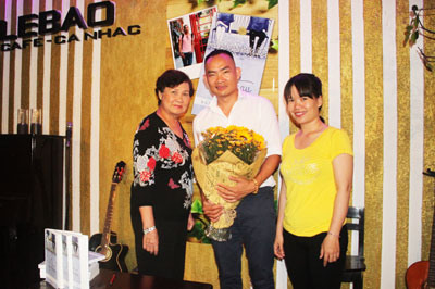 Nguyễn Hữu Tại (giữa) nhận hoa của độc giả trong buổi ra mắt sách ở Nha Trang.