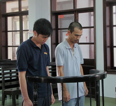 Bị cáo Hồ Hoàng Chinh (trái) và Đinh Ngọc Nguyên Vũ tại phiên tòa ngày 27-4.