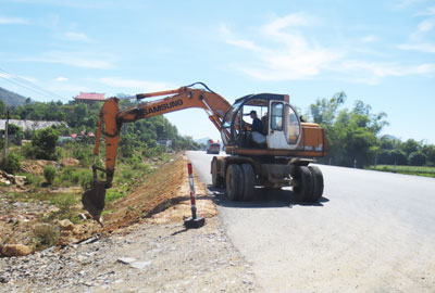 Các nhà thầu đang hoàn thiện phần nền đất ven Quốc lộ 1A đoạn qua xã Vĩnh Phương.