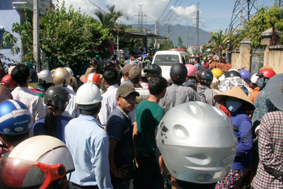 Hàng trăm người dân hiếu kỳ tụ tập trên đường dẫn đến căn nhà nạn nhân.